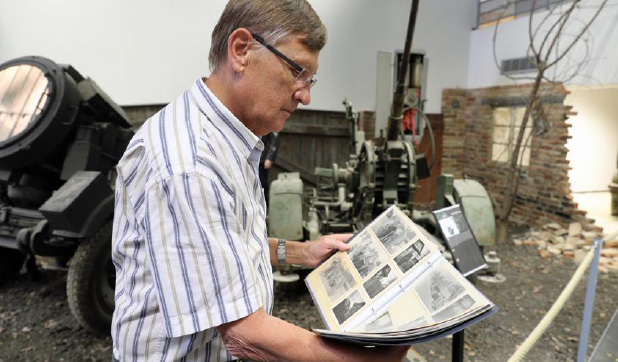 André Fuchs devant un projecteur et un canon de la Flak, comme celui qu’utilisait son père, qui est mis en scène au MM